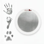 LARLEAF silver round mess free ink pad featuring the brand logo. Shown next to sample prints of a hand, baby foot, and dog paw print. Circular mess-free print kit ideal for DIY Pet Memorials Goods