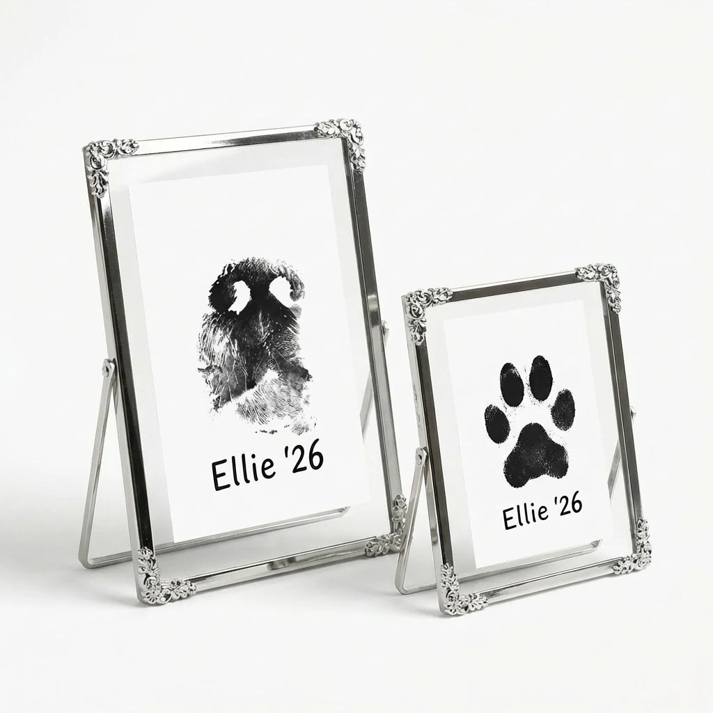 Elegant silver keepsake frames with filigree corners. Perfectly frames a black ink dog nose print and a matching paw print. These delicate metal frames add a touch of vintage charm to any home decor while honoring a beloved furry friend. Main image