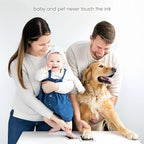 A happy family with their baby and a golden retriever, simultaneously creating a baby footprint and a dog paw print using safe, inkless pads. Text says "baby and pet never touch the ink