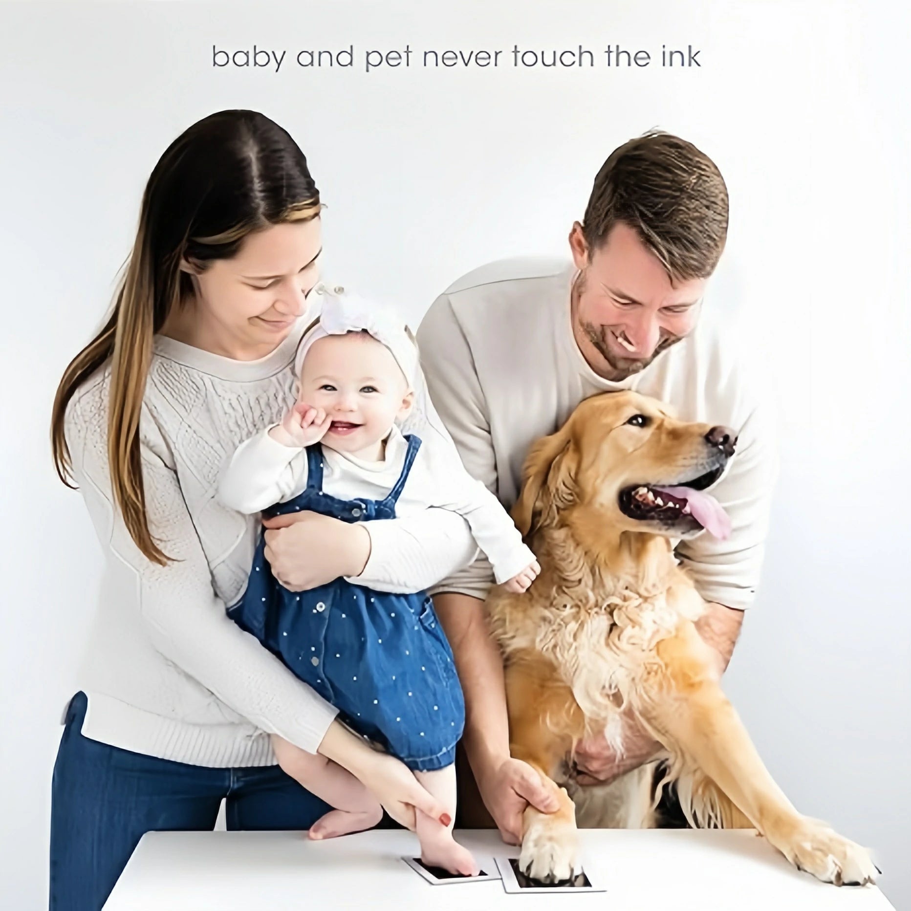 A happy family with their baby and a golden retriever, simultaneously creating a baby footprint and a dog paw print using safe, inkless pads. Text says "baby and pet never touch the ink
