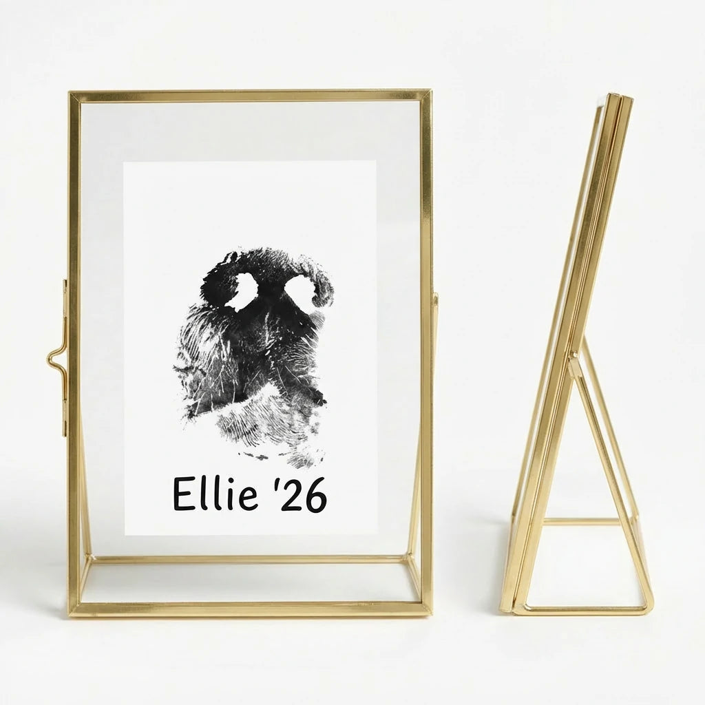 Gold brass metal picture frame with a floating glass design, displaying a DIY black dog nose print. The side view reveals a sleek geometric easel stand for stability. An ideal personalized dog memorial gift or bereavement keepsake, this frame preserves the memory of a pet with a modern, minimalist aesthetic suitable for US home decor