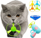 A grey British Shorthair cat holding a green flying saucer disc in its mouth. Beside it is a Larleaf light blue interactive toy gun with pink stars, accompanied by colorful replacement discs and a blue glowing gyroscope.