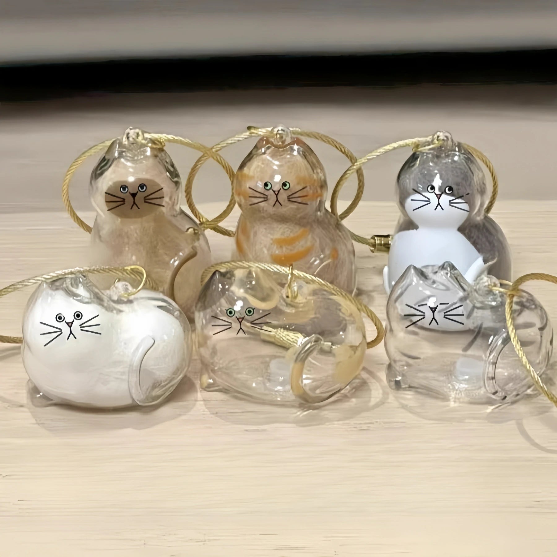 A collection of Larleaf cat-shaped clear keychains designed for pet hair storage. These memorial containers allow pet owners to keep a lock of fur as a souvenir. Features cute cat faces and golden wire loops for hanging.