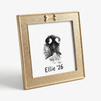 Ideally sized gold dog memorial gift: A square frame with a decorative golden bone accent. Holds a personalized nose print art 'Ellie 26'. This matte gold frame adds a touch of elegance to any dog lover's home decor. Perfect for a desk or shelf.