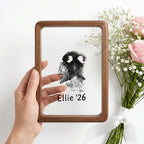 Hand holding a premium walnut wood floating frame with rounded corners to display transparency and compact scale. Features a custom dog nose print (paw print) on clear glass. The unique see-through design offers a modern, airy tribute for pet remembrance